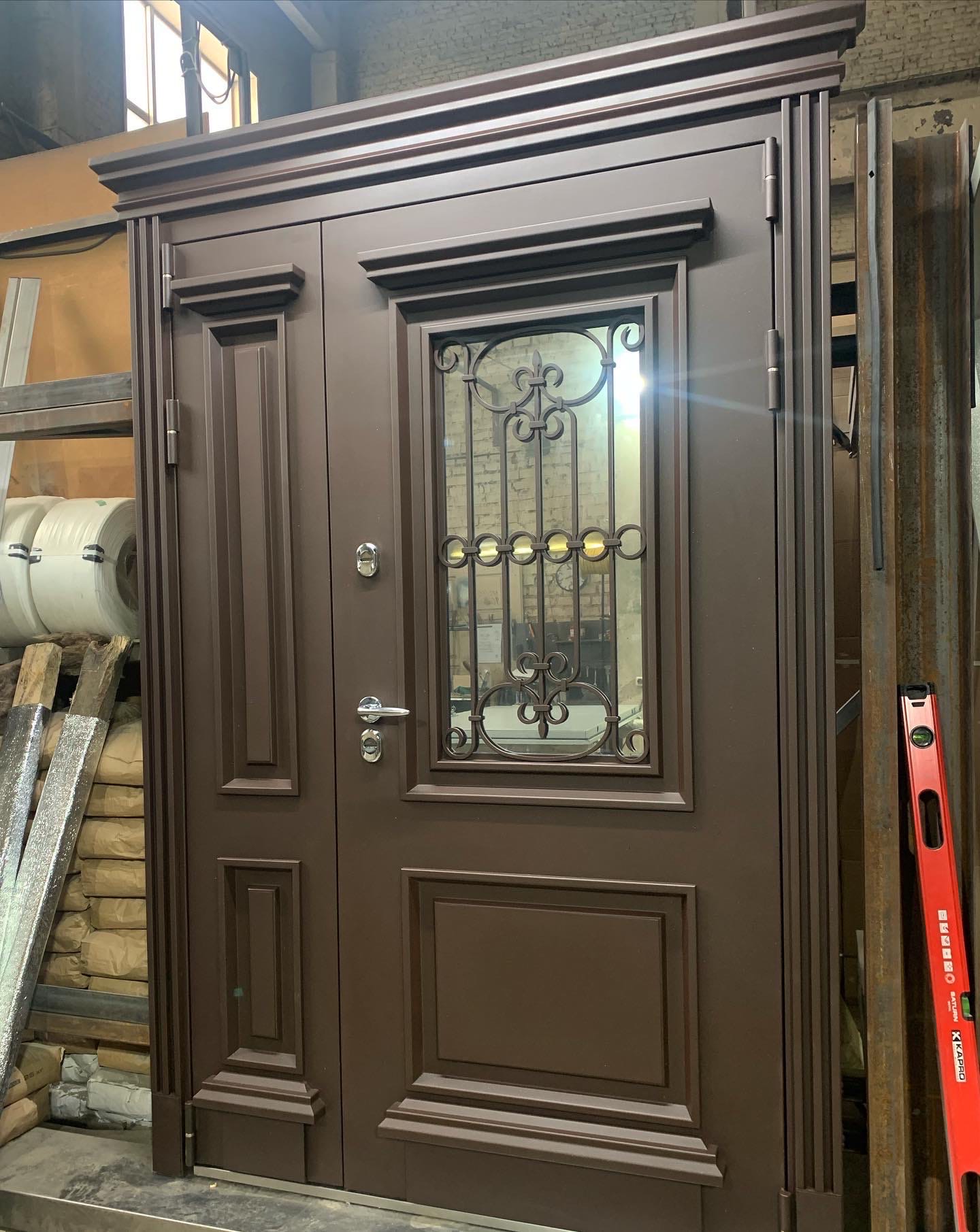 Нестандартная уличная дверь в классическом стиле с «металлофилёнками», багетной рамкой и карнизом